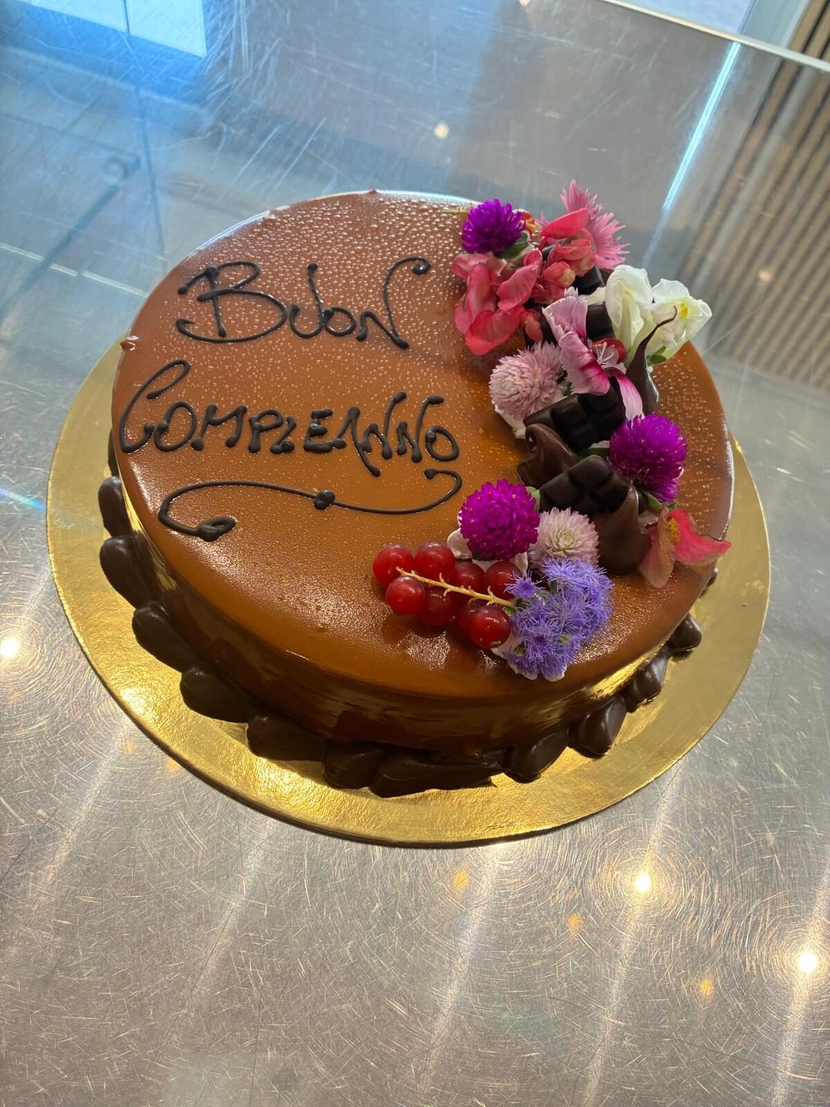Torta di compleanno al cioccolato con fiori e ribes